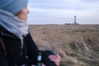 Close-up of woman against light house