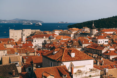 High angle view of townscape by sea against sky