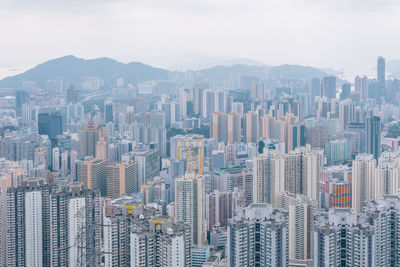 Aerial view of buildings in city against sky