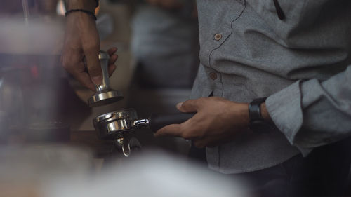 Midsection of man holding coffee cup