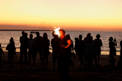 Group of people on beach during sunset