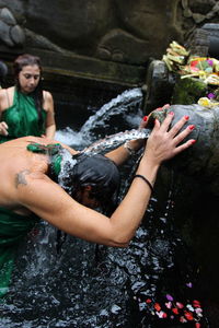Woman taking bath in fountain at temple