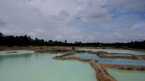 Scenic view of lake against cloudy sky