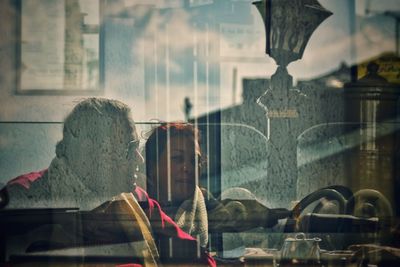 Digital composite image of woman with reflection on glass window