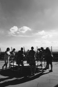 People playing on carousel against sky at park