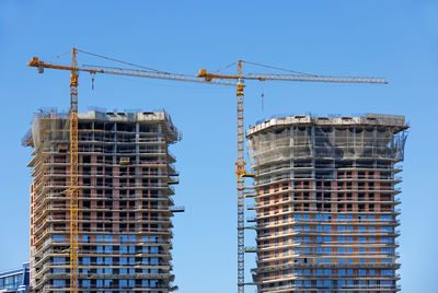 Modern construction of multi-storey twin towers of residential buildings with help of tower cranes