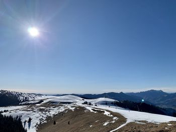 Scenic view of snowcapped mountains against blue sky