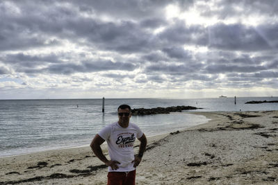 Man standing at beach against sky