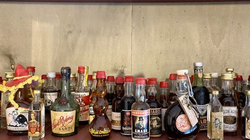 Panoramic shot of bottles on shelf against wall