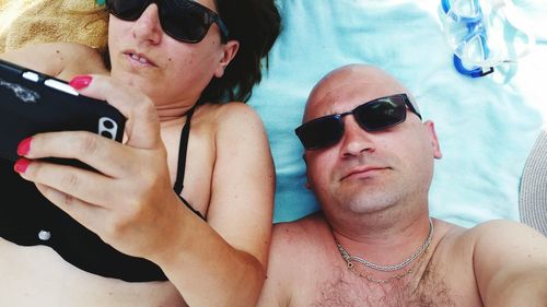 Woman with man using mobile phone at beach