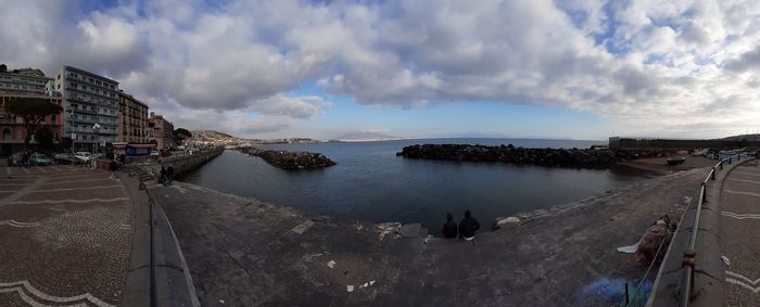 High angle view of buildings by sea against sky