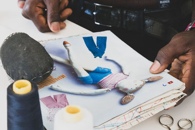 High angle view of man holding painting on table