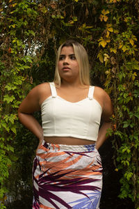 Portrait of young woman against plants