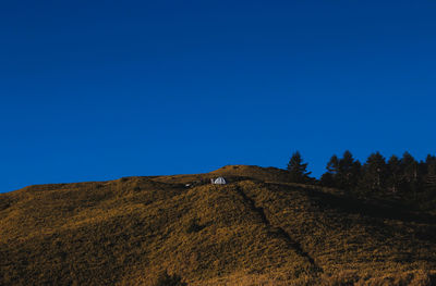 Low angle view of mountain against clear blue sky