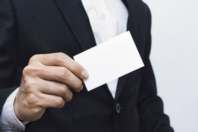 Midsection of man holding paper