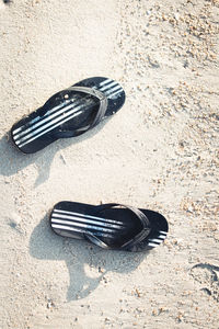 Directly above shot of flip-flop on sand