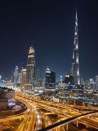 Light trails on road against buildings at night