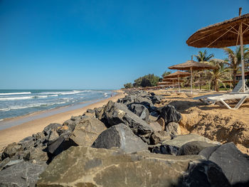 Rocks on beach against clear blue sky