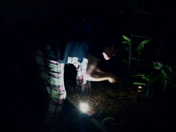 Low section of woman standing by the dark