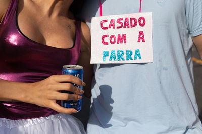 People are seen having fun with a sign saying married to the party during fuzue, pre carnival 