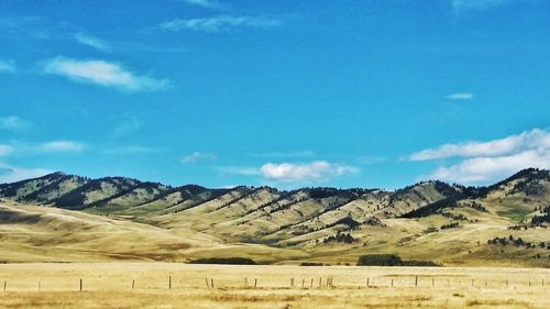 Scenic view of field and mountains against sky