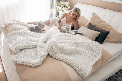 Woman lying down on bed at home