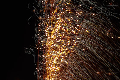 Low angle view of firework display against sky at night