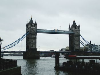 Bridge over river against cloudy sky