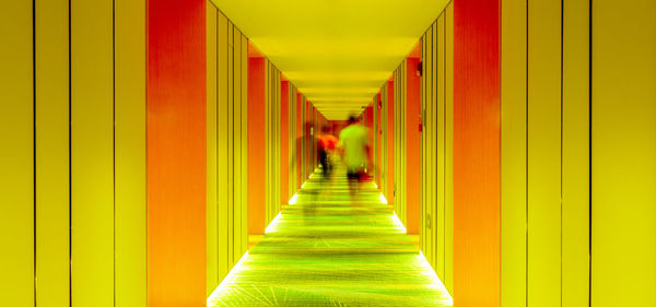Rear view of people walking in corridor of building
