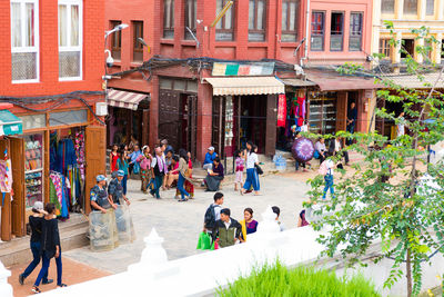 People walking on street against buildings in city