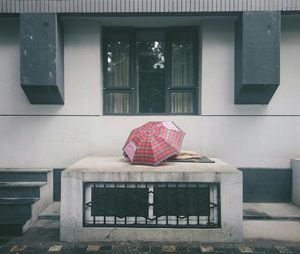 Homeless person sleeping under umbrella on porch