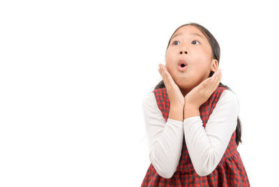 Girl making a face while standing against white background