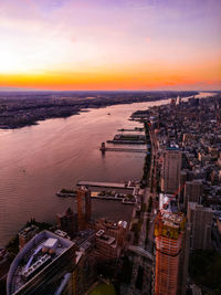 High angle view of city lit up at sunset