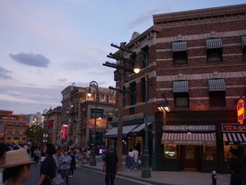 People walking on street in city against sky