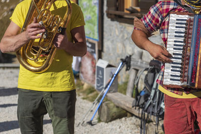 Midsection of man playing guitar on street