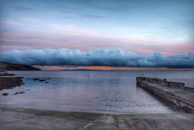 Scenic view of calm sea against cloudy sky