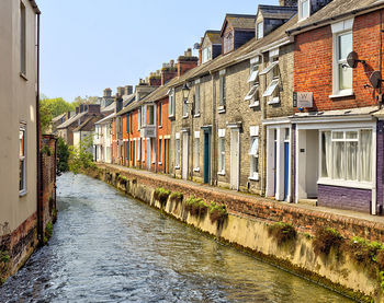 Canal amidst buildings against sky