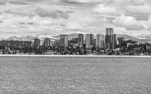 The cascades mountain range has snow with bellevue, washington in front.