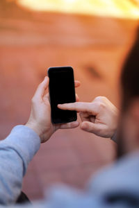Midsection of man using smart phone
