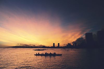 Silhouette boat sailing in sea against sky during sunset