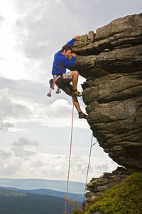 Rock climber on cliff at the peak district in england