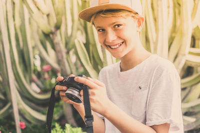 Portrait of smiling boy holding camera