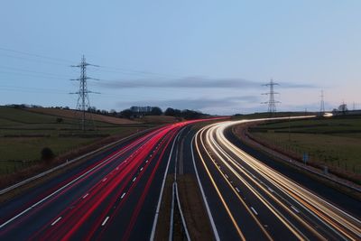 Light trails on highway against sky