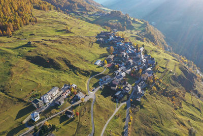 High angle view of houses on field by mountain