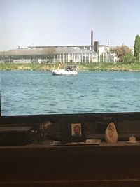 Boat in river against buildings in city