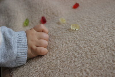 Cropped hand of baby on carpet