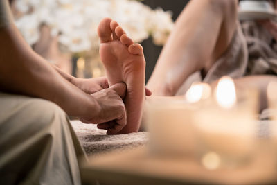 Midsection of woman giving foot massage to customer in spa