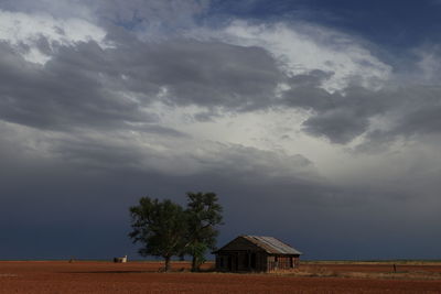 House on field by building against sky