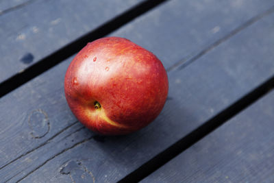 A nectarine lying on a blue cutting board