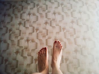 Low section of woman standing on tiled floor